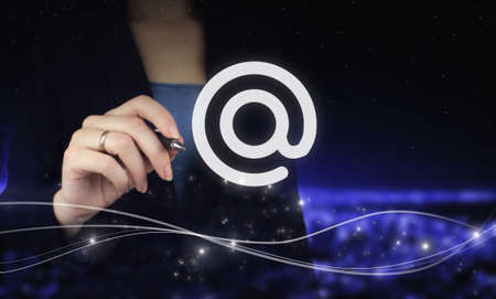 Business email concept. Hand holding digital graphic pen and drawing digital hologram Email sign on...
