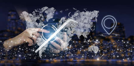 Rule the world, world domination concepts. Hand touch white tablet with digital hologram world, earth, map, Location Marker sign on city dark blurred backgroundの写真素材