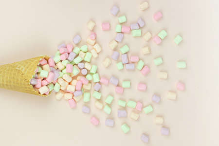food background. Wafer horn and marshmallow on a pastel background, top view, flat lay, minimalist trendの写真素材