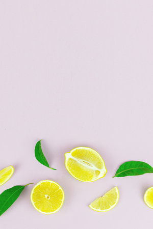 Fresh lemon fruit and leaves composition on pastel background. Minimal summer fruit or vegetarian conceptの写真素材