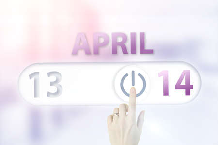 April 14th. Day 14 of month, Calendar date.Hand finger switches pointing calendar date on sunlight office background. Spring month, day of the year conceptの写真素材