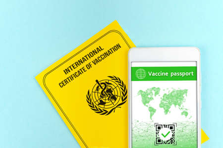 Yellow international certificate of vaccination with digital health passport app in mobile phone,...