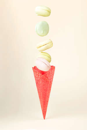Colored marshmallow looks like macaroons falling in Waffle horn on a pink pastel backgroundの写真素材