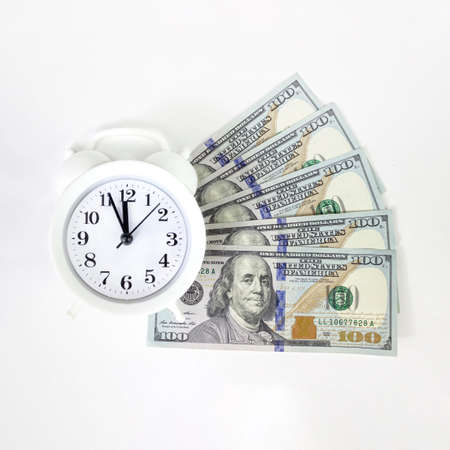 Time is money. Gray alarm clock on money banknotes Dollars. finance and business.の写真素材