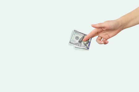 Hand giving money on white background. Cropped Hand Of Woman Hold Paper Currencies On White Background.の写真素材