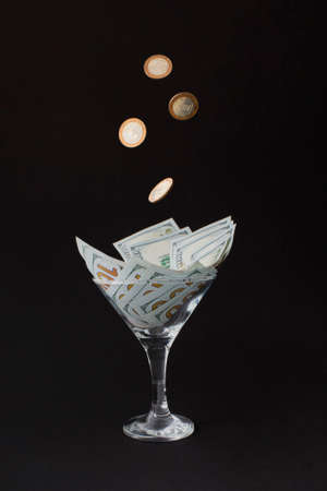 Money Cocktail business concept toast with falling gold coins money in motionの写真素材