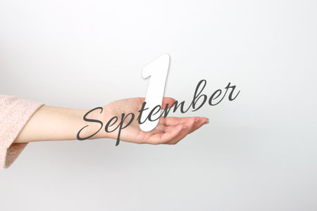 September 1st. Day 1 of month, Calendar date. Calendar Date floating over female hand on gray background. Autumn month, day of the year conceptの写真素材