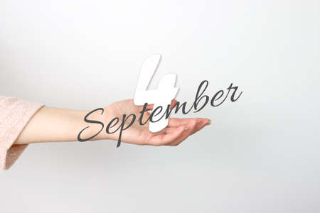 September 4th. Day 4 of month, Calendar date. Calendar Date floating over female hand on gray background. Autumn month, day of the year conceptの写真素材