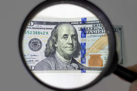 Magnifying glass on dollar banknotes. Checking suspicious money of magnifying glassの写真素材