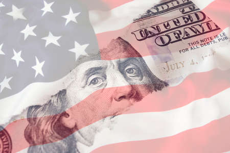 Portrait of US president Benjamin Franklin 100 dollars banknote on american flag background. economy, savings and the US dollarの写真素材