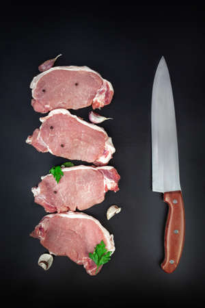Raw veal meat fillet, Variety of raw beef meat steaks for grilling with meat knife on dark backgroundの写真素材