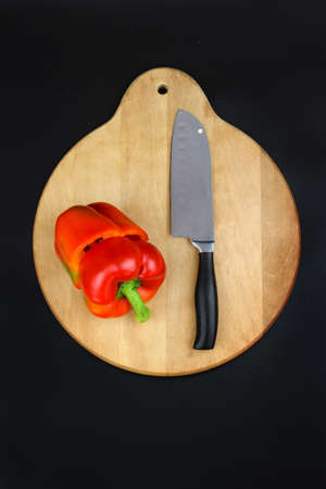 Close-up of reb bell pepper which is cut by sharp kitchen knifeの写真素材