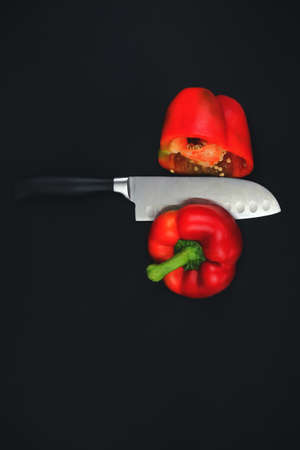 Big kitchen knife cut a bell pepper on two parts close upの写真素材