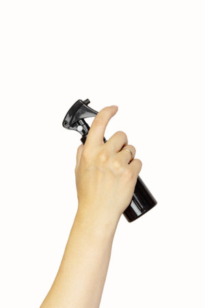 Female hand holding hair accessories hair sprayer over white background, copy space. Set of hairdresser's tools on white backgroundの写真素材