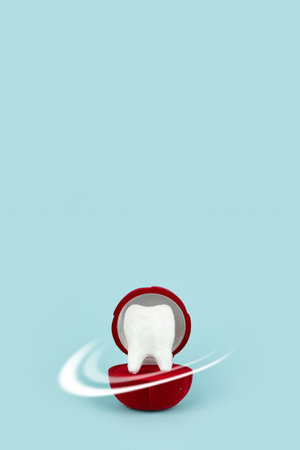 Protective vortex around tooth model in gift box on blue backgroundの写真素材