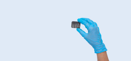 Female dentist hand in blue medical gloves holds x-ray of tooth. light background. Concept of oral hygiene in the family.の写真素材