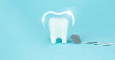 Foam vortex around white tooth and dentist mouth mirror, protection and whitening, protected teeth glowing brightly on a blue background. Professional Dental concept. Dentist stomatology medicalの写真素材