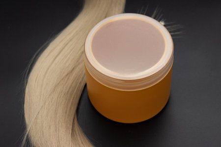 Blond long hair with cream oil jar of ripe wheat. Healthy hair. Accessories for haircut with copy space. Split Ends Repair Treatment. Hair care spa concept.の写真素材