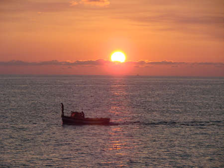 Boat with fishmans and sunset on Bleak See