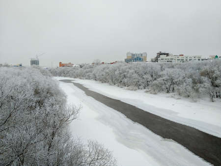 Omsk, Russia - December 18, 2018: View of the winter river Om flowing through the center of Omsk, surrounded by beautiful trees covered with hoarfrostのeditorial素材