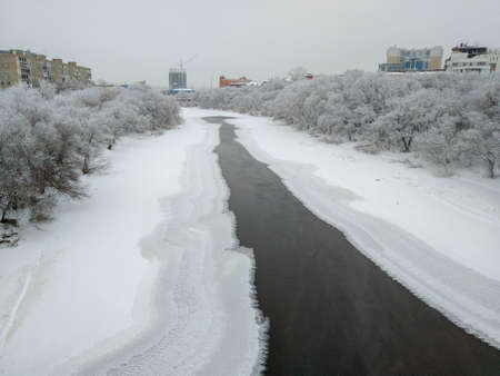 Omsk, Russia - December 18, 2018: View of the winter river Om flowing through the center of Omsk, surrounded by beautiful trees covered with hoarfrostのeditorial素材