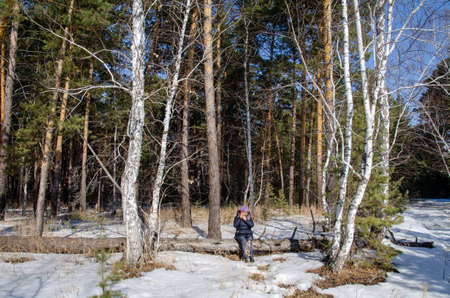 Woman talking on a mobile phone in the Siberian forest, Omsk regionの写真素材
