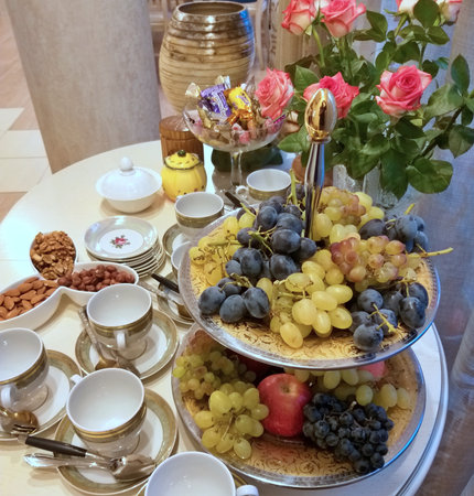 Tea table with a vase of fruit and flowersの写真素材