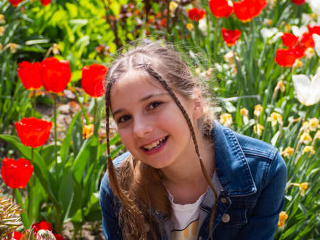 Beautiful smiling teen girl. A happy girl with a beautiful hairstyle in the rays of the spring sun,...
