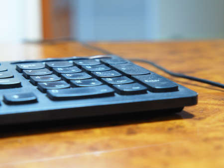 Close-up of a black computer keyboard on an office desktop, Shallow depth of field. A working...