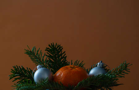 Festive background for New Year and Christmas with tangerines, festive toy balls and branches of a...