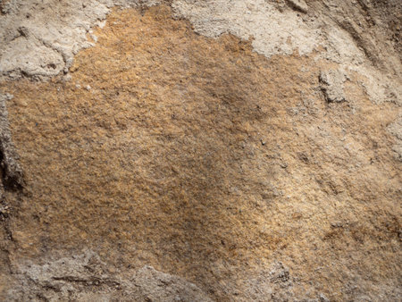 Close-up of sand-colored stone tiles on the wall. Abstract natural stone stone texture background for design. A stone wall. Brownstones. A wall with gray seams- Background. Rough, cold stone.の写真素材
