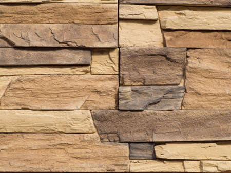 Decorative stone wall for the background. Stone brick texture background. The brown wall is lined with stone tiles, background textureの写真素材