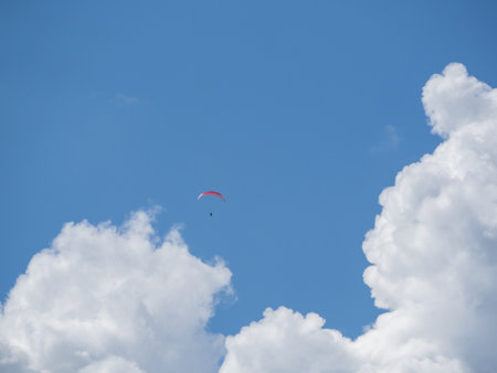 Huge white clouds in a blue sky and a small paragliderの写真素材