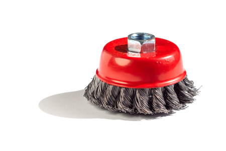 Metal cup brush, for cleaning surfaces from rust and paint, on a white background. The brush is a cup made of twisted wire. metal brush for a grinding machine on a white backgroundの写真素材