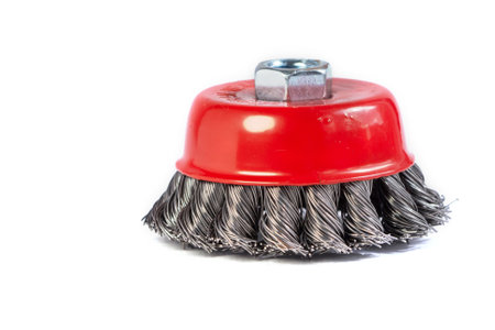 Metal cup brush for cleaning surfaces from rust and paint on a white background. The metal brush for the grinding machine is a cup made of twisted wireの写真素材