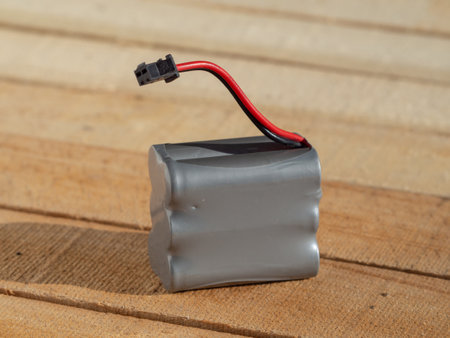 Battery for radio-controlled toys. Lithium-ion battery for radio-controlled toys close-up on a wooden backgroundの写真素材