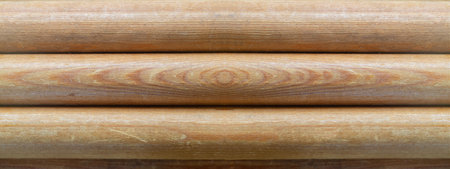 Texture of a wooden background made of rounded logs close-upの写真素材