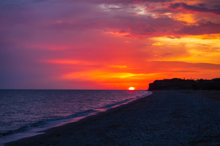 Beautiful bloody sunset over the sea and a sandy-shell beach in a beautiful tourist destination. Amazing nature landscape seascape. colorful sky backgroundの写真素材
