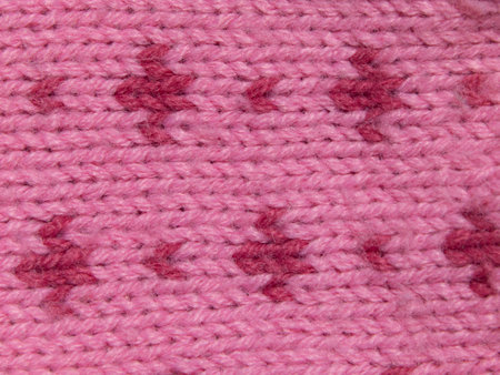 Macro abstract pink background texture of machine-knitted yarn fabric with a patternの写真素材