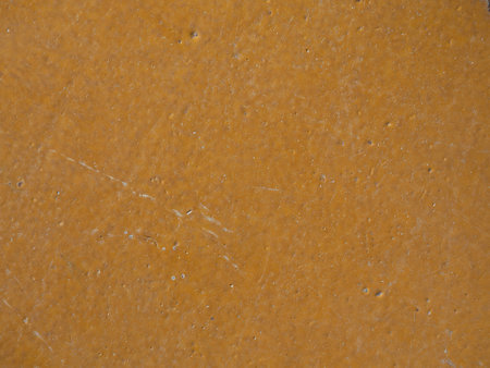 Texture of an old painted surface with scuffs and scratches for a close-up background. Mustard-colored background textureの写真素材