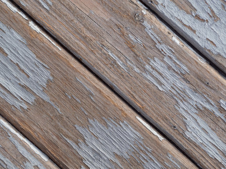Texture of diagonally arranged wooden boards with remnants of gray paint close-upの写真素材