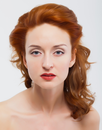 Beautiful woman touching face, clean skin, red hairs, red nails. White isolated background.の写真素材