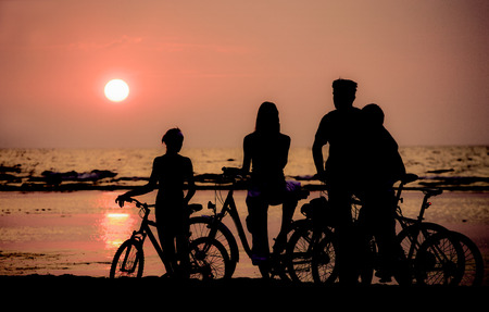 Family rest on bicycles during Sunset.の写真素材