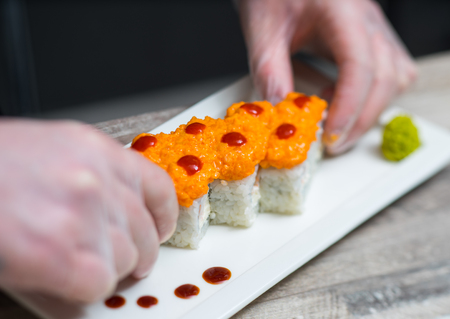 Making sushi rolls. Sushi master, cutting sushi rolls.の写真素材