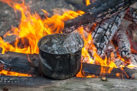 Cauldron with ice on fire in forest. Cooking in the nature.の写真素材