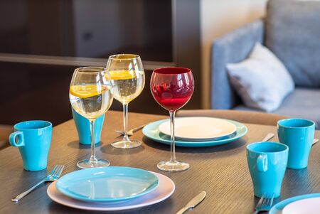 Served table with blue and white plates, blue cups and wine glasses