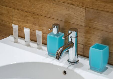 Soap on the sink. Shower gel. Body lotion. Blue glass.