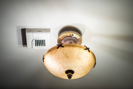 Lamp and chandelier. Shadows. White ceiling.