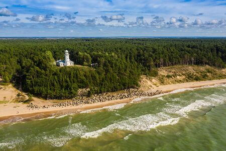 White Uzhava lighthouse on the shore of Baltic Sea. Sunny day.の写真素材