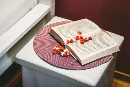 Close-up of the composition of book and sweets on the bedside.